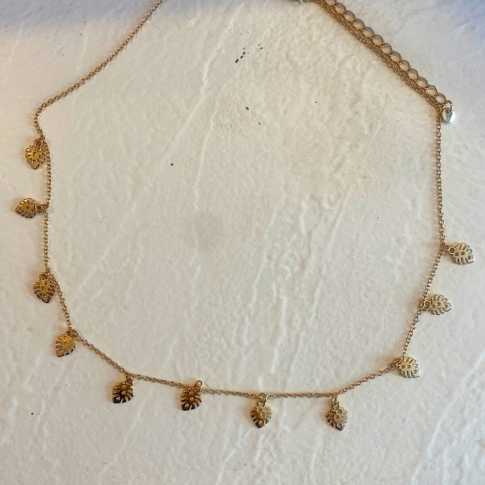 This is a brand new, gold choker. It has dangling leaves.